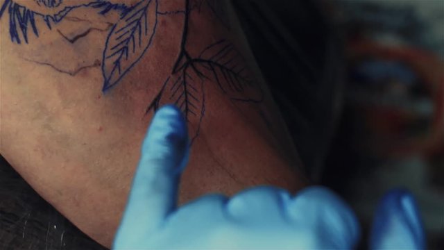 Close-up of Male Tattooist Making Tattoo Using Drawing Sketch. Tattoo Artist Working Process.