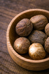 Nutmeg, close-up, aromatic spice, wooden background