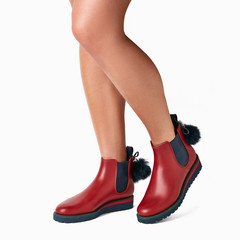 Women red and blue chelsea boots with fur ball on behind. Weared on legs,  white background