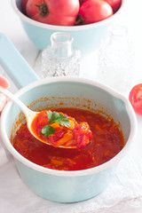 tomato sauce with vegetables in an enamel ladle, selective focus