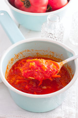tomato sauce with vegetables in an enamel ladle, selective focus