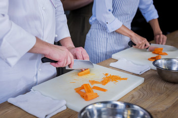 Guests. Confident nice cooks being serious while preparing a delicious dish for guests