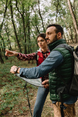 couple of travelers with map got lost in woods