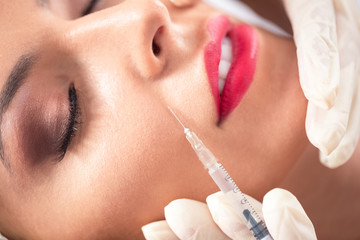 Stunning woman doing botox in a beauty salon