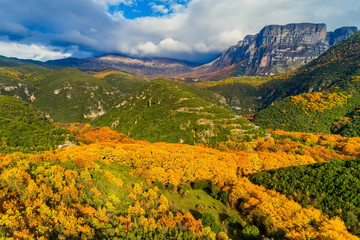 Fototapeta na wymiar Aerial view of the the Vikos Gorge in the autumn and provincial road with many zigzag in the Epirus Zagorohoria, Greece. National park