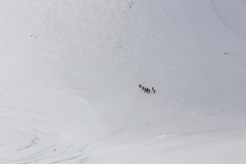Snowy winter alpine landscape on a sunny day, with shadows and shimmering snow.