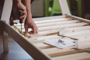 close up hands of a man, a man screws a screwdriver, instruction and construction roulette, self-Assembly of furniture