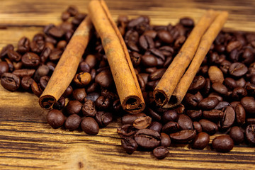 Coffee beans and cinnamon sticks on rustic wooden background