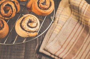 fresh rolls with poppy on a metal lattice/fresh rolls with poppy on a metal lattic on a dark wooden background, top view