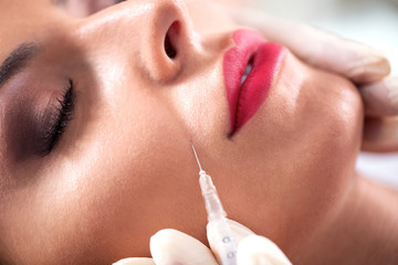 Beautiful woman doing wrinkle treatment near lips with botox
