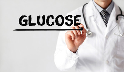 Doctor writing word Glucose with marker, Medical concept