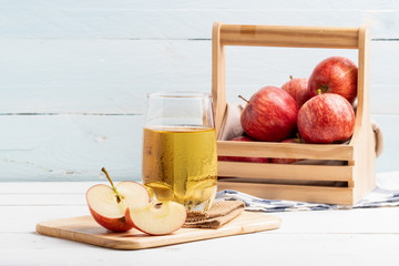 One glass of apple juice and fresh apple on white background.
