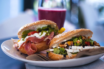 Breakfast table. Sandwiches and red smoothie with a magazine. Healthy meal conception.