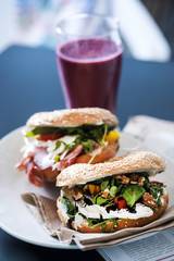 Breakfast table. Sandwiches and red smoothie with a magazine. Healthy meal conception.