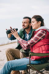 side view of couple with binoculars having camping