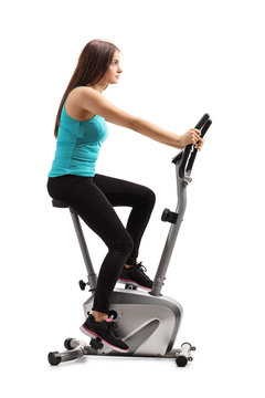 Young Female Riding A Stationary Bike