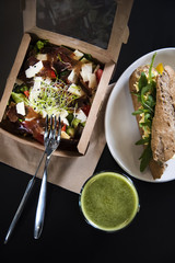 Take away fresh salad in a lunch box, sandwich and smoothie. Top view shot. Gourmet conception. 