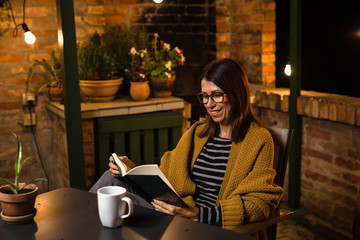 She likes to spend evening reading book in her backyard