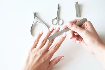 Fotobehang Woman making manicure with nail care tools background. French manicure. © alexngm
