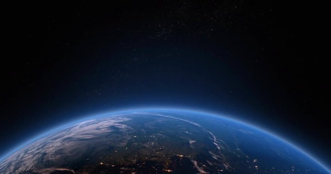 Earths atmosphere as viewed from space with the suns light starting to rise as the earth rotates.