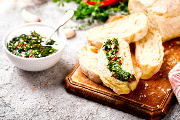  Argentinian green Chimichurri with ingredients.Raw homemade with ciabatta.Salsa or sauce made of parsley, garlic, oregano, hot pepper, olive oil, vinegar.Food Concept.