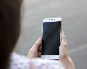girl holds a smartphone in the hands of social networks in everyday life work on the smartphone
