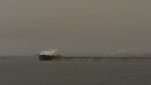 LNG tanker loading alongside jetty of petrochemical port