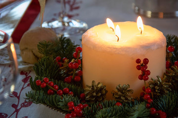 christmas centerpiece with big candle and red berries