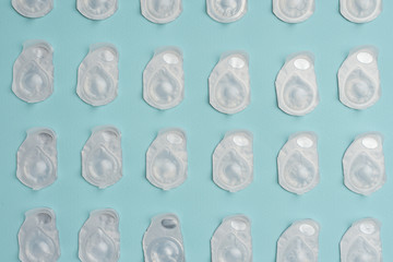 flat lay with contact lenses in containers arranged on blue background