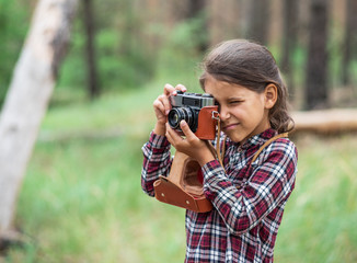 Young photographer. Small girl with camera.