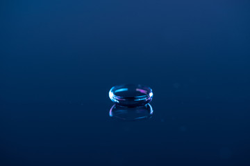 close up view of contact lense on blue backdrop