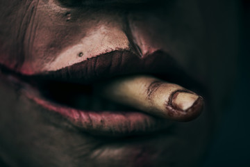 scary man with an amputated finger in his mouth - obrazy, fototapety, plakaty