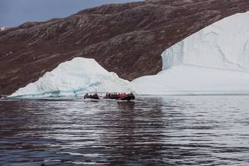 Sierkussen Poolcirkel rubber dinghy cruising in front of massive Icebergs floating in the fjord scoresby sund, east Greenland    © Mario Hagen