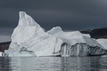 Gordijnen rubberboot cruisen voor enorme ijsbergen die in de fjord drijven scoresby sund, oost-Groenland © Mario Hagen
