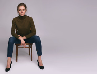 pretty casual woman is sitting on a chair