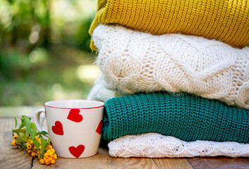 Fall decoration with a cup of coffee and wool clothes