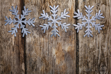 Obraz na płótnie Canvas Christmas snowflakes on a wooden background