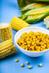 Raw and canned corn in a white bowl.