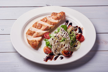 Grilled chiken fillet. Raw vegetables, wooden background