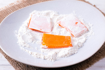 Sliced pumpkin in flour