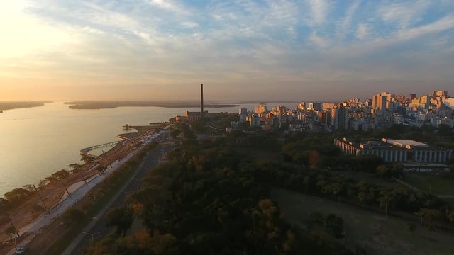 Beautiful aerial scene of a city in sunset, at margin of a lake. Shoot in 4k. Location: Porto Alegre, south of Brazil.
