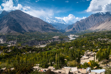 Aerial view landscape of green Hunza valley and Nagar in October, separated by river and surrounded by Karakoram mountain range. Gilgit-Baltistan, Pakistan.