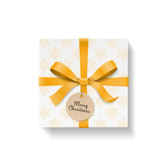 Square gift box, gold color bow knot and ribbon with circle kraft hang tag. Yellow snowflake pattern paper. Merry Christmas text on ball. Happy New Year package. Vector illustration 3d top view
