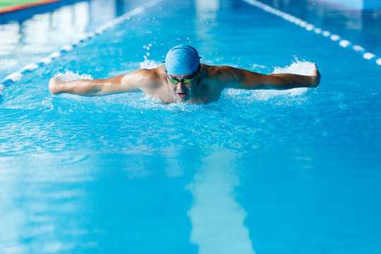 Photo of sportive man swimming along path in pool