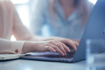 Close up shot businesswoman working on a laptop with her hands in the office with a modern design