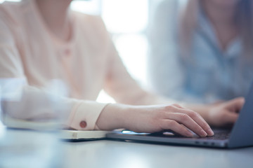 Close up shot businesswoman working on a laptop with her hands in the office with a modern design