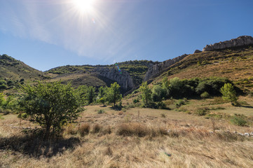 View of a valley in Leon mountain (Spain) during a trekking activity with the sun creating a flare effect