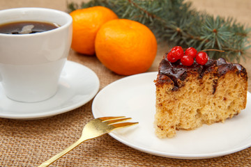 Chocolate cake decorated with bunch of viburnum and cup of coffee.