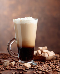 Coffee drink or cocktail with cream and pieces of brown sugar.
