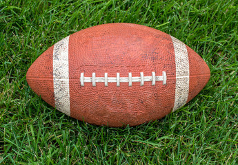 Obraz premium used football centered on green turf